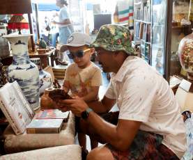 A relaxed moment inside a Nanaimo vintage shop, where an adult and child explore together among shelves of unique antiques and collectibles.