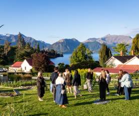 A group of people at Walter Peak walking through the kitchen garden with views of the lake and mountains in the background