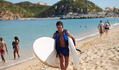 hombre saliendo del mar con tablas de surf