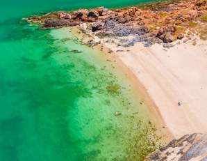 Aerial view of Honeymoon Pool at Point Samson in the Pilbara showing the beach, bushland and water.