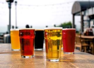 Several glasses of beer on a wooden table