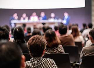 People in audience of conference presentation