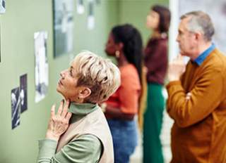 People looking at photo display on green wall