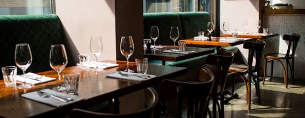 Restaurant table set up with light coming in through windows