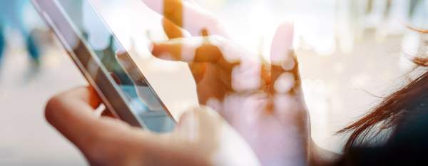 Hands using a smartphone in a public setting, representing digital accessibility and inclusion.