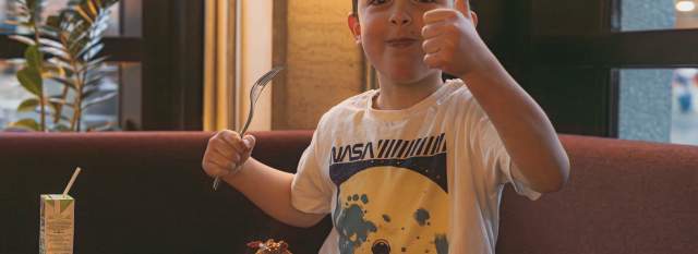 A boy next to a plate full of food