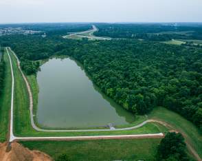 Lake surrounded by greenery and wooded areas, with paved hiking trails at Buffalo Lake in Elizabethtown, Kentucky