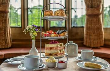 an afternoon tea display on a table with bay window in background