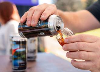 Hand pouring a hand of beer into a glass