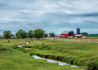 A large field and small stream on a farm