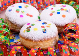 Three powdered donuts covered with colorful confetti