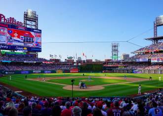 People sitting behind home plate in Citizens Bank Park stadium watching the Philadelphia Phillies play baseball