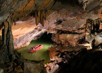 A small boat making its way through an underground cave