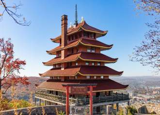 Tiered, red pagoda overlooking a city