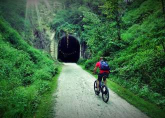a person on bike riding Infront of a tunnel