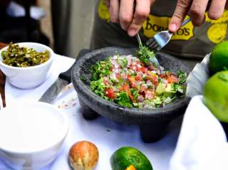 Guacamole being made in a molcajete
