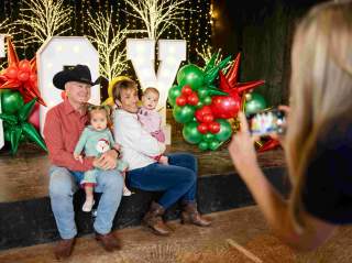 Man and woman holding two children taking a photo
