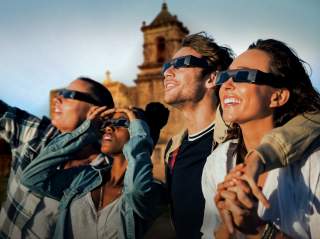 Group of people with protective sunglasses on in front of San Antonio Missions National Historical Park