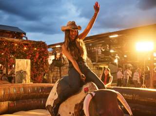 Girl on mechanical bull at Tejas Rodeo