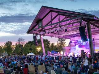 A crowd enjoys a concert at the Nickel Plate District Amphitheater in Fishers, IN at sunset