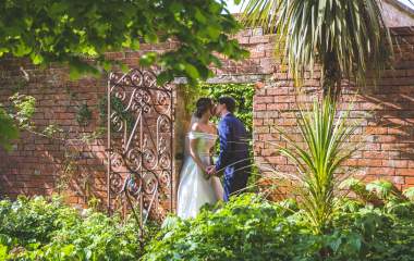 The Manor House Hotel- a couple embrace under a red brick arch way in the garden