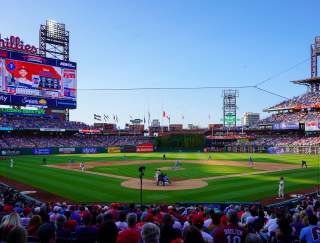 People sitting behind home plate in Citizens Bank Park stadium watching the Philadelphia Phillies play baseball