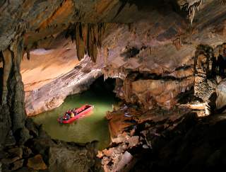 A small boat making its way through an underground cave