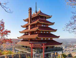 Tiered, red pagoda overlooking a city