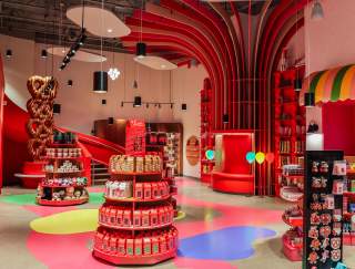 Interior of a colorful chocolate store with product stands in the middle of the room