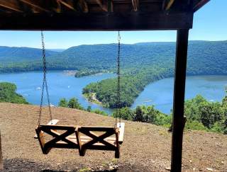 A swing overlooking a lake on a sunny day