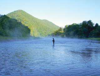 Person with a fishing rod in a large lake