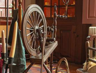 Rustic Interior With Cabinets, Chairs And Spinning Wheel At Stephen Hopkins House