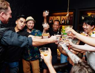 Several people clink glasses at Tales of the Cocktail event in 2023