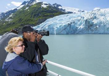 Couple photographs Portage Glacier during glacier cruise