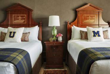 Two beds with U-M pillows at Graduate Ann Arbor