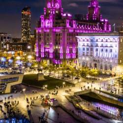 Liverpool Pier Head with a focus on royal Liver building which is lit up pink