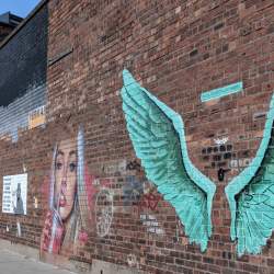 A wall in the Baltic Triangle featuring the iconic street artwork 'For all Liverpools Liver Birds' two giant wings.