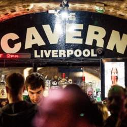 The bar inside the Cavern Club with the words 'The Cavern' painted in white capitals letters on a black archway