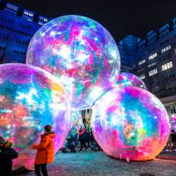 Giant multicoloured bubbles in the dark at night time