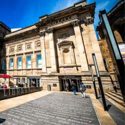 Exterior of Liverpool Central Library, an impressive sandstone building with large columns and details.