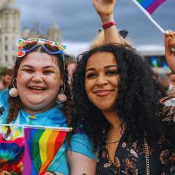 Two girls with pride flags on Liverpool Pier Head