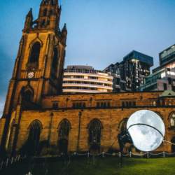 An old church building with a moon being 'lassoed' outside