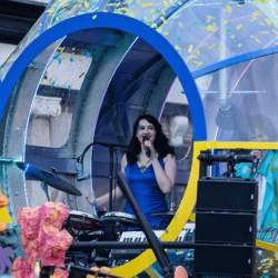 a blue and yellow submarine with people inside performing a DJ set