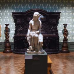 A sculpture of a woman in an ornate gallery