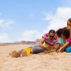 A family playing on the beach making sandcastles