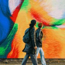 Two people looking at colourful street art