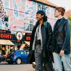 Two people walk past Rockpoint Records in New Brighton.