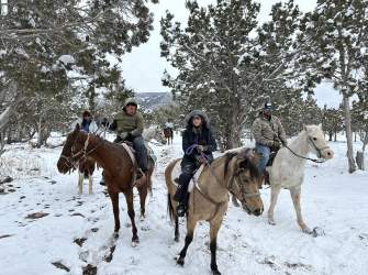 group of people on a winter trail horseback ride