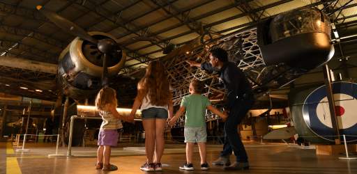 A family looking up at an aircraft at Brooklands Museum