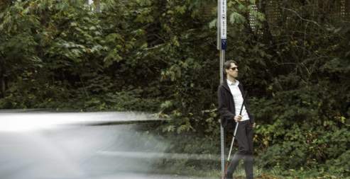 man waiting by a bus stop